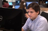 Homem de camisa azul clara trabalhando em computador Dell em um escritório.