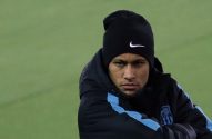 Neymar sério, de touca Nike e jaqueta do FCB, em campo verde.