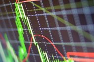 Gráfico de velas do mercado financeiro em tela. Velas verdes mostram alta, linhas vermelhas indicam tendências de baixa.