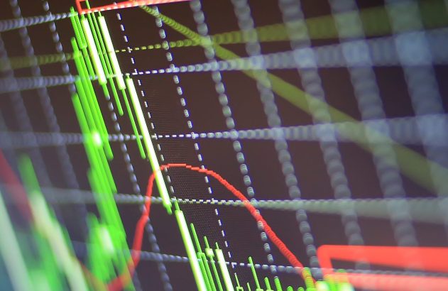 Gráfico de velas do mercado financeiro em tela. Velas verdes mostram alta, linhas vermelhas indicam tendências de baixa.