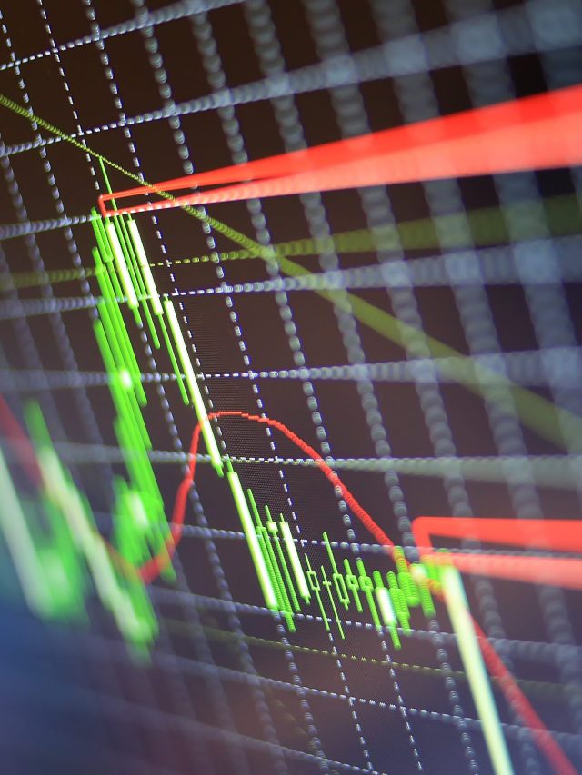 Gráfico de velas do mercado financeiro em tela. Velas verdes mostram alta, linhas vermelhas indicam tendências de baixa.