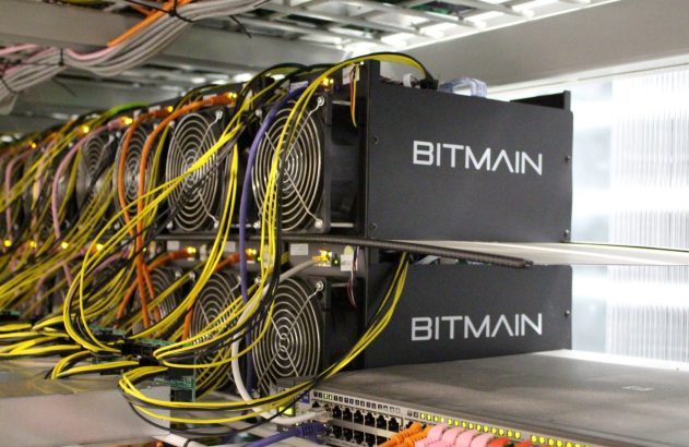 Máquinas BITMAIN com muitos cabos coloridos e ventiladores em datacenter, conectadas a switch ativo.