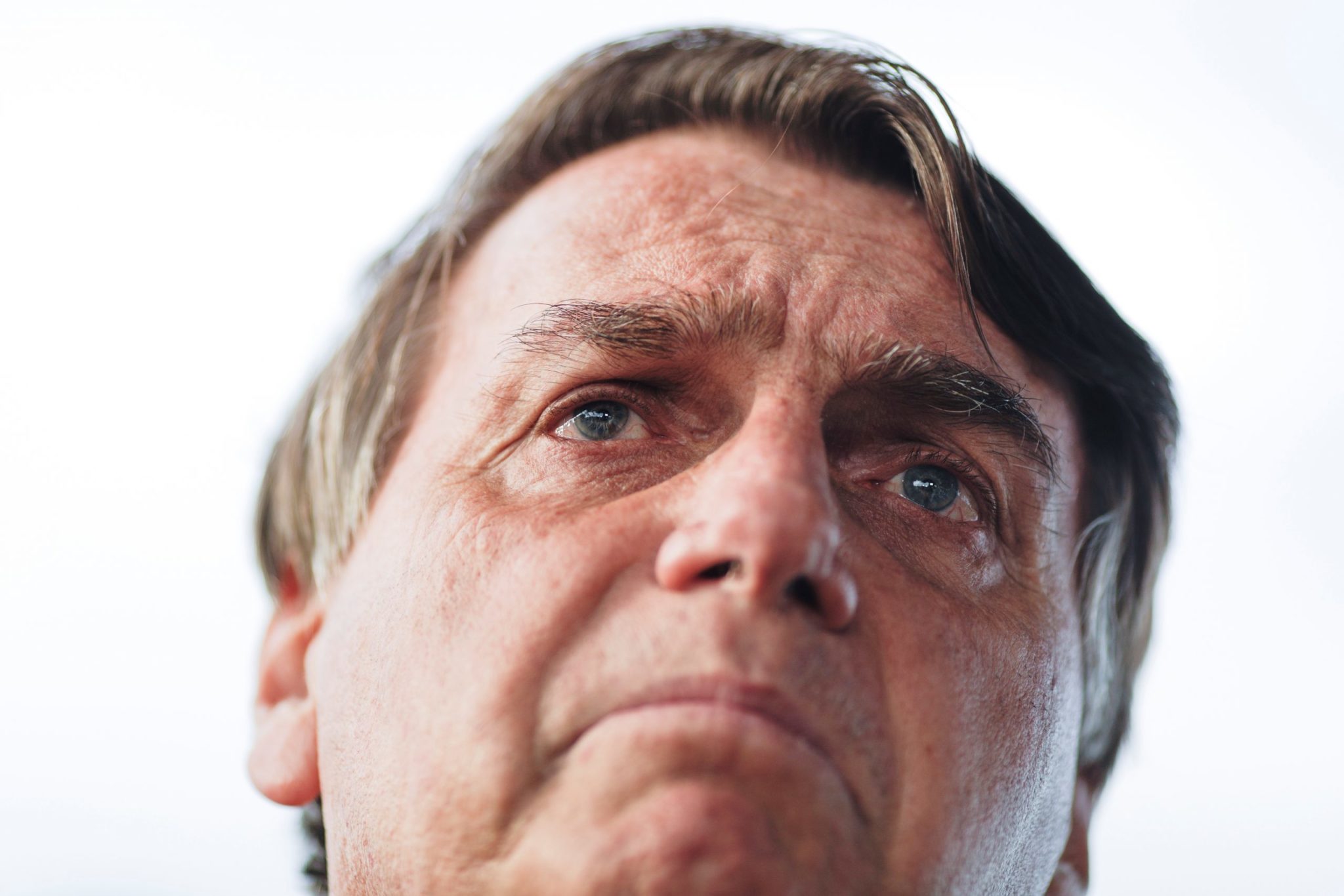 na imagem, o presidente Jair Bolsonaro com expressão de preocupação, com fundo branco