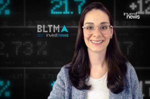 Apresentadora sorridente de óculos em estúdio com gráficos financeiros e logos da investnews.