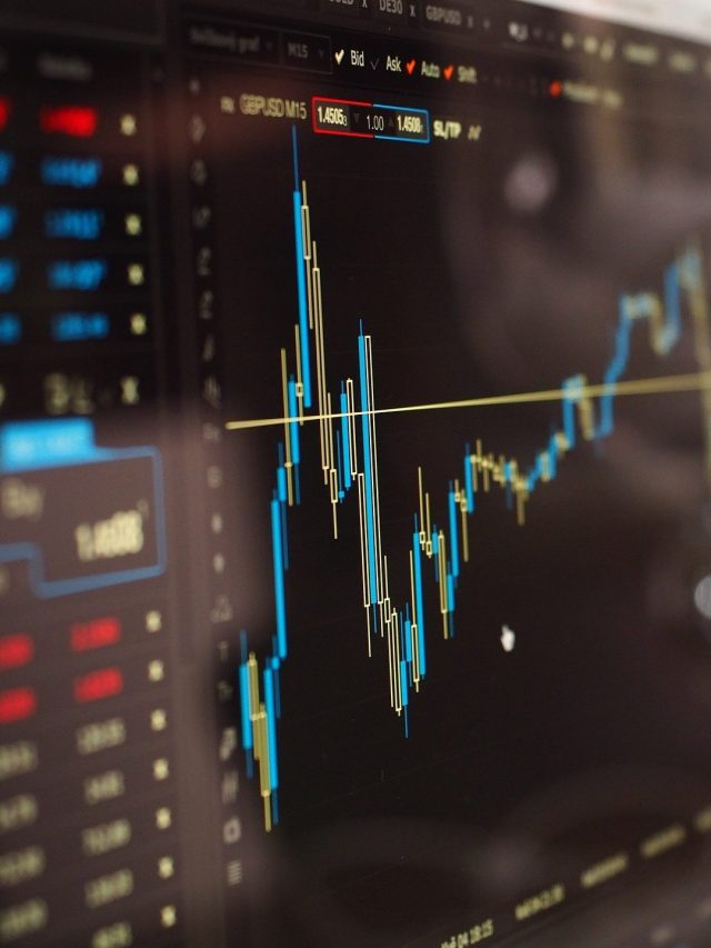 Gráfico Forex com candlesticks azuis e dourados em tela de computador de trading.