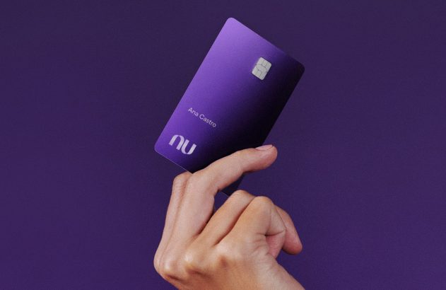 Mão segura cartão roxo Nu com chip e nome Ana Castro.