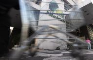 Movimento de pessoas e carrinhos de supermercado em frente ao Pão de Açúcar, com uma criança observando.