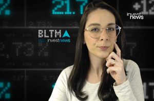 Mulher de óculos, mão no queixo, com fundo digital exibindo dados financeiros e logos Investnews e BLTMA.