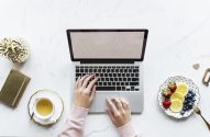 mãos femininas com um laptop em uma mesa com frutas