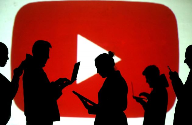 Silhuetas de pessoas segurando laptops, tablets e celulares, projetadas em um fundo vermelho com o logo do YouTube.