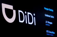 Um monitor escuro exibe o logo branco da DiDi e uma lista de instituições financeiras, como Morgan Stanley e Goldman Sachs.