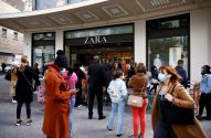 Fila de pessoas na entrada de uma loja Zara, várias usando máscaras.