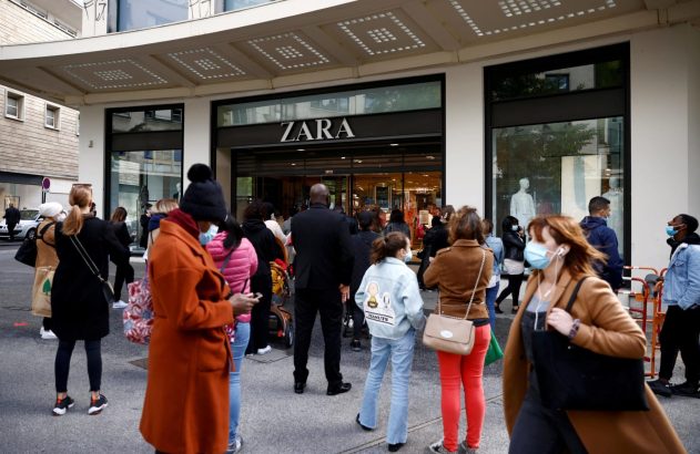 Fila de pessoas na entrada de uma loja Zara, várias usando máscaras.