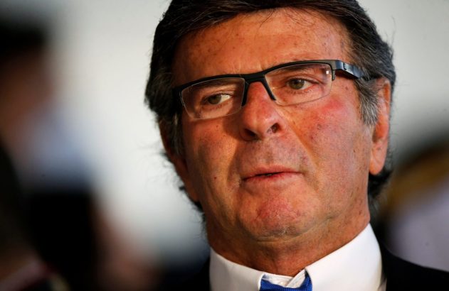 Close-up de homem de óculos e gravata azul olhando para a direita.