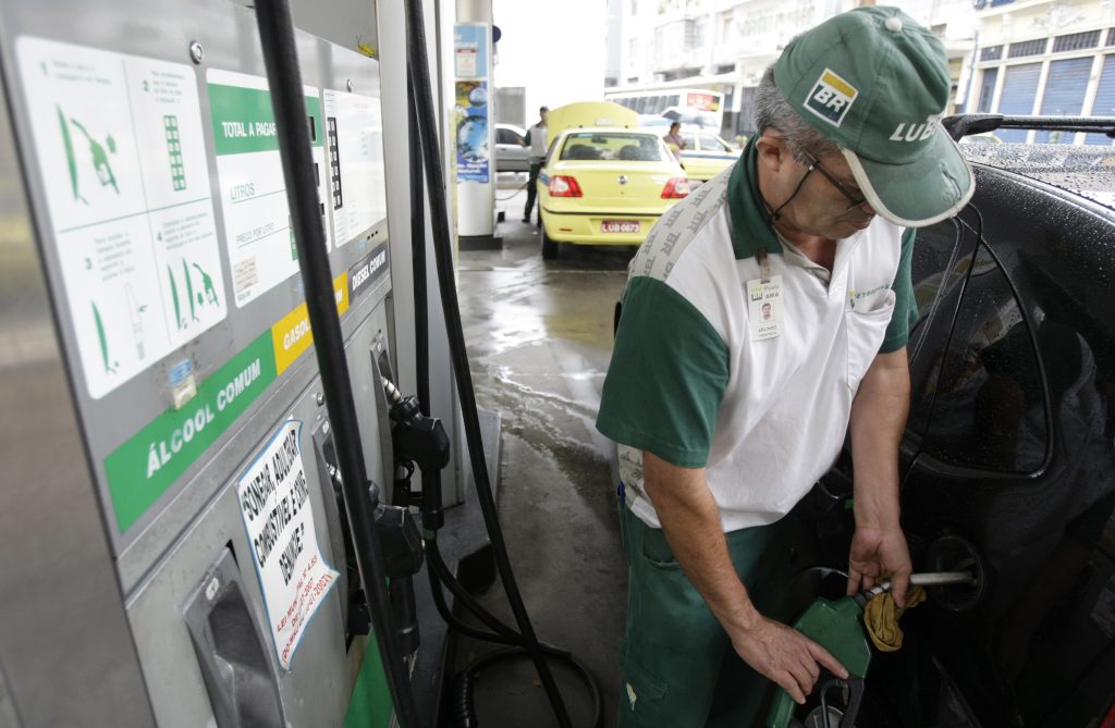 Frentista abastecendo o carro com gasolina.
