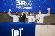 Quatro homens comemoram listagem da 3R Petroleum na B3. Fundo azul com logo e confetes; pódio com símbolo '[B]³'.