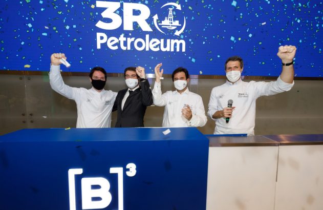 Quatro homens comemoram listagem da 3R Petroleum na B3. Fundo azul com logo e confetes; pódio com símbolo '[B]³'.