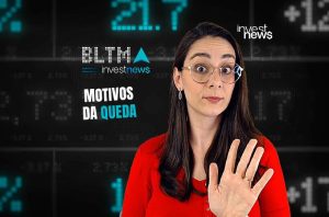 Mulher com óculos e blusa vermelha gesticulando, expressão surpresa. Fundo com dados financeiros e texto "MOTIVOS DA QUEDA".