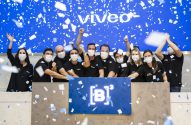 Grupo com máscaras celebra evento da Viveo na B3 com confetes.