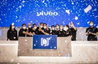 Grupo de pessoas celebrando em evento com confetes caindo. Telão azul ao fundo com "vivéo" e logo da B3.