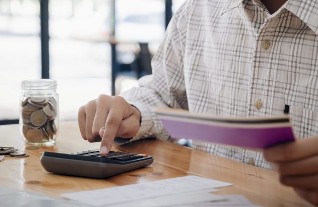 Pessoa faz cálculos em uma calculadora