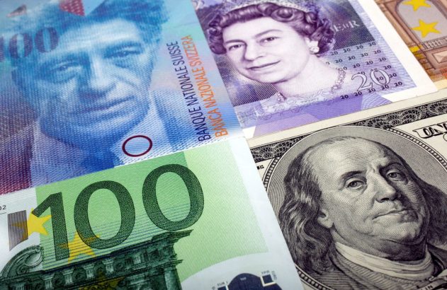 Notas de 100 francos suíços, 20 libras, 100 euros e dólar americano (Franklin) sobrepostas.