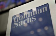 Logotipo "Goldman Sachs" em placa azul e prateada.