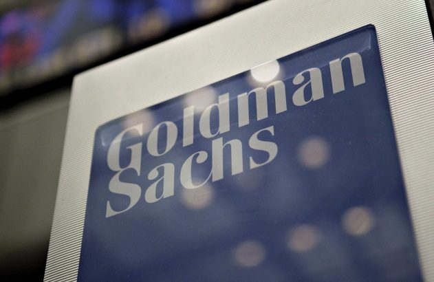 Logotipo "Goldman Sachs" em placa azul e prateada.