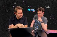 Dois homens em estúdio. Um aponta para laptop, o outro observa. Cena de transmissão "invest news" ao vivo.