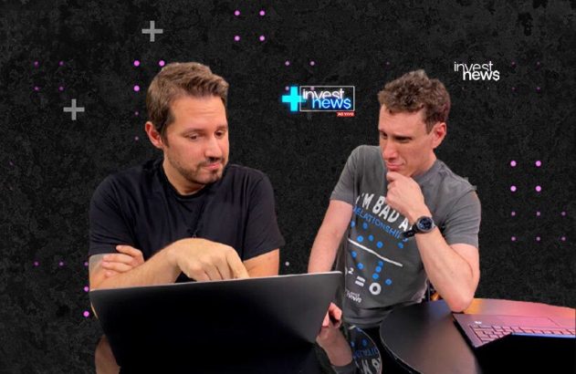 Dois homens em estúdio. Um aponta para laptop, o outro observa. Cena de transmissão "invest news" ao vivo.