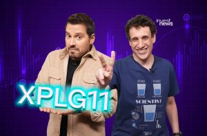 Dois homens em um estúdio com gráficos financeiros. Um segura 'XPLG11' e o outro sorri fazendo sinal de paz.
