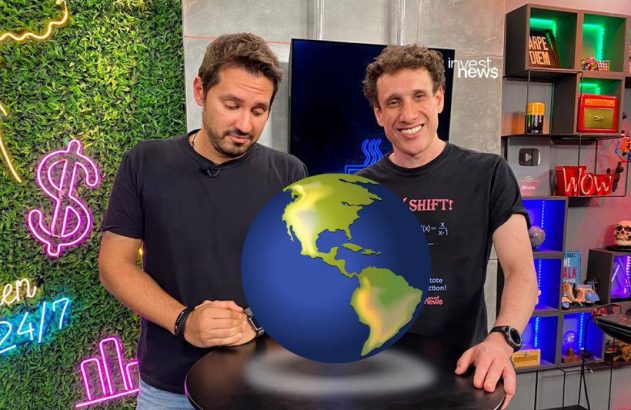 Dois homens em estúdio Invest News. Um globo terrestre 3D flutua entre eles; um homem o olha, o outro sorri.