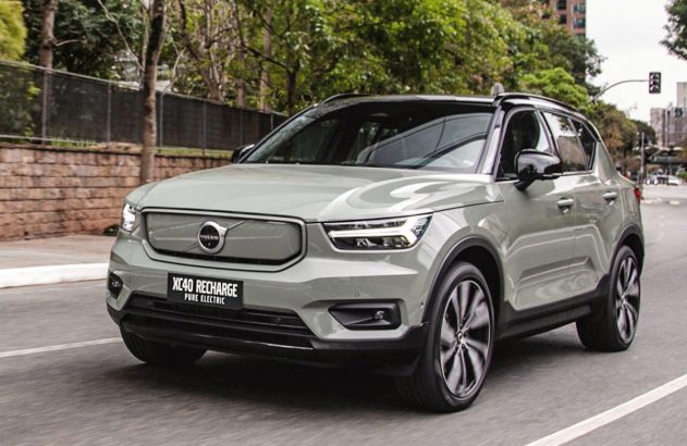 SUV Volvo XC40 Recharge elétrico cinza-esverdeado em movimento na rua.