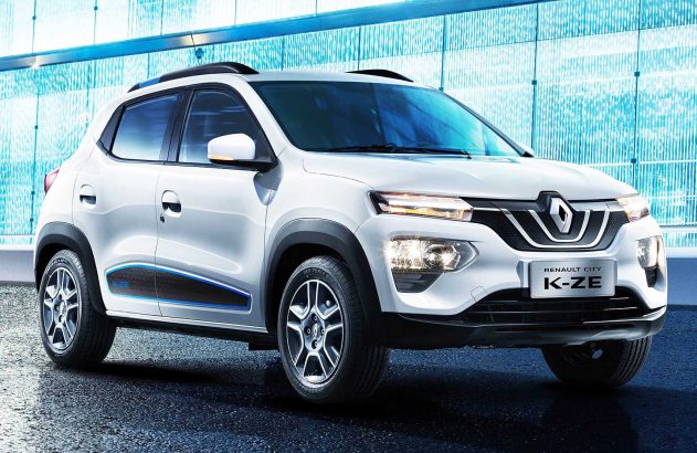 Carro branco Renault City K-ZE, um SUV compacto, estacionado. Detalhes em preto e azul. Fundo: prédio moderno azul.