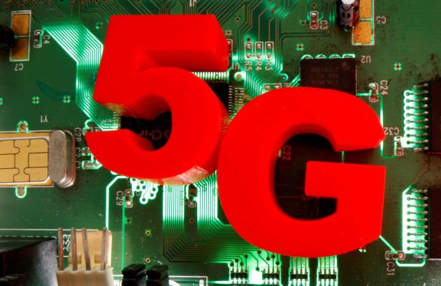 Letras 5G vermelhas em destaque sobre uma placa de circuito eletrônico verde iluminada.