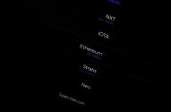 Tela escura exibe lista de criptomoedas: Ethereum, IOTA, Stratis. Opção "Comprar Instantaneamente" presente.