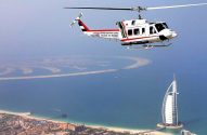 Helicóptero voando sobre Dubai, mostrando o Burj Al Arab e as ilhas Palm ao fundo.