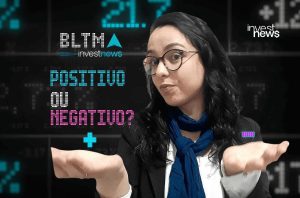Apresentadora da Investnews gesticula questionando: "POSITIVO OU NEGATIVO?" sobre tela financeira.