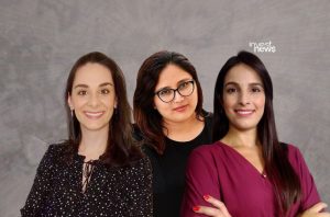 Três mulheres sorrindo em foto de estúdio, com logo 'invest news'.