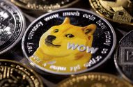 Moeda Dogecoin física com o cão Shiba Inu em foco. Outras criptomoedas estão desfocadas ao fundo.