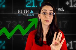 Apresentadora de notícias financeiras com óculos e camisa vermelha, mostrando 4 dedos. Fundo com gráficos de ações.