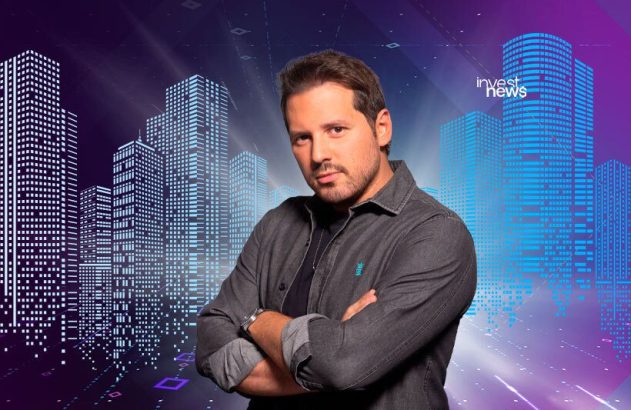 Homem de braços cruzados olhando para a câmera, com fundo de cidade digitalizada e logo "invest news".