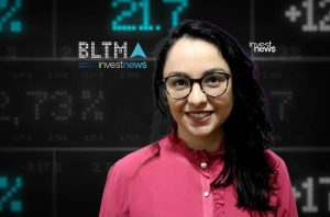 Apresentadora sorridente de óculos em estúdio com tela digital de dados financeiros e logo Investnews ao fundo.