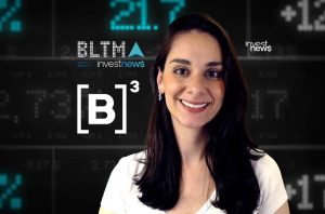 Uma mulher sorrindo em frente a um fundo digital com dados financeiros e o logo "investnews".