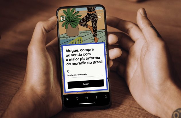 Mãos seguram smartphone com app de moradia. Na tela: "Alugue, compre ou venda com a maior plataforma de moradia do Brasil".