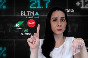 Mulher com expressão de dúvida aponta para cima e para baixo. Ao fundo, dados financeiros e logos de empresas.
