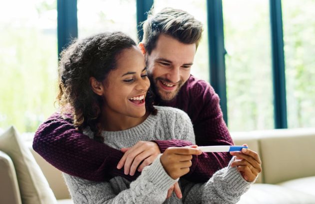 Mulher e homem com teste de gravidez na mão