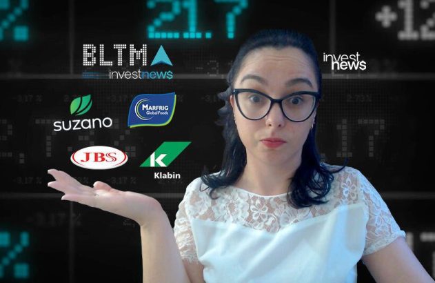 Mulher surpresa gesticula, em frente a logos de empresas (JBS, Suzano) e painel financeiro ao fundo.