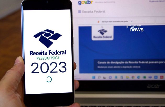Pessoa com celular e notebook exibindo o app e site da Receita Federal (Imposto de Renda 2023).