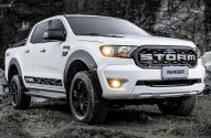 Ford Ranger Storm 4x4 branca em terreno off-road lamacento e rochoso, com faróis acesos.